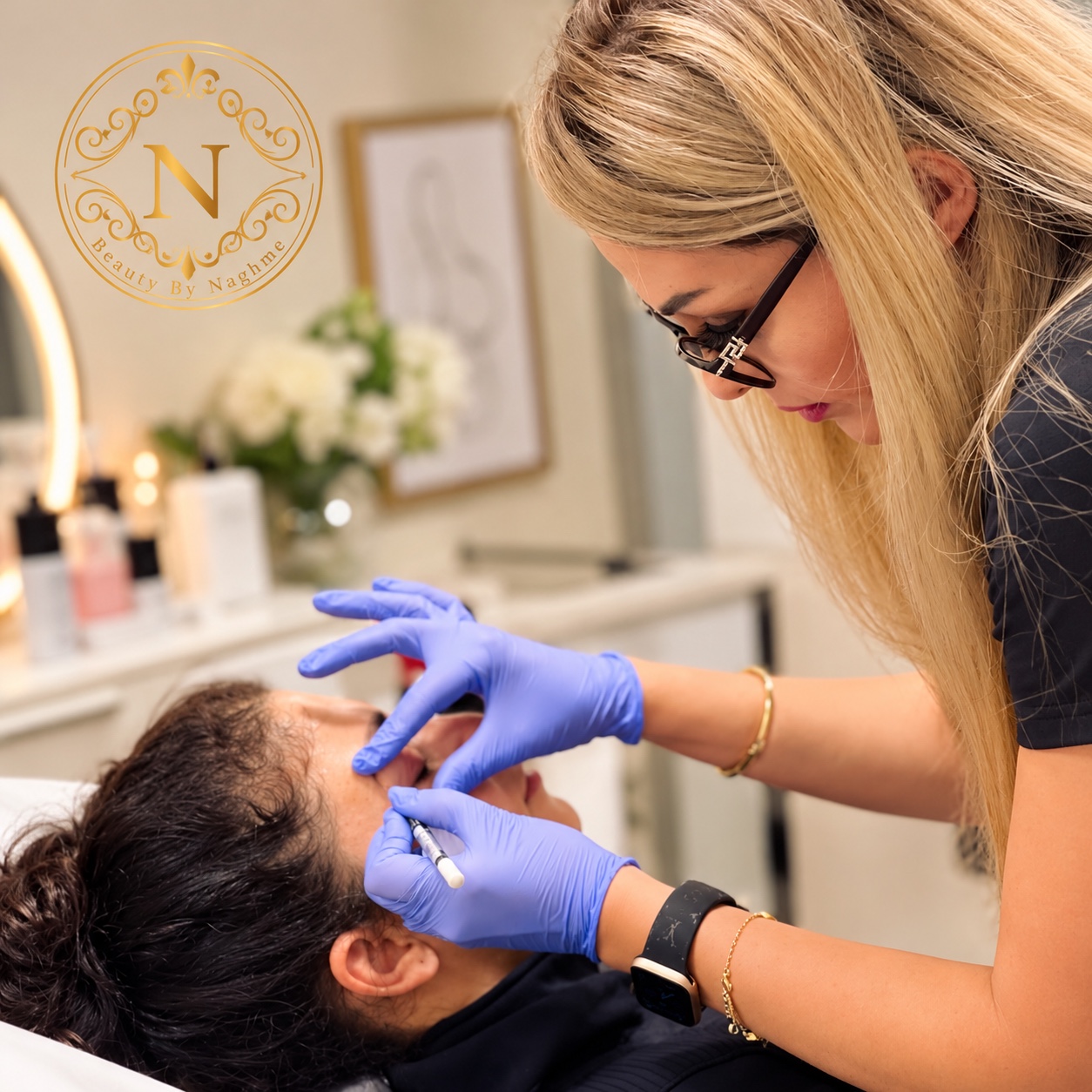 Naghmeh performing an aesthetic treatment, with the clinic’s gold N monogram